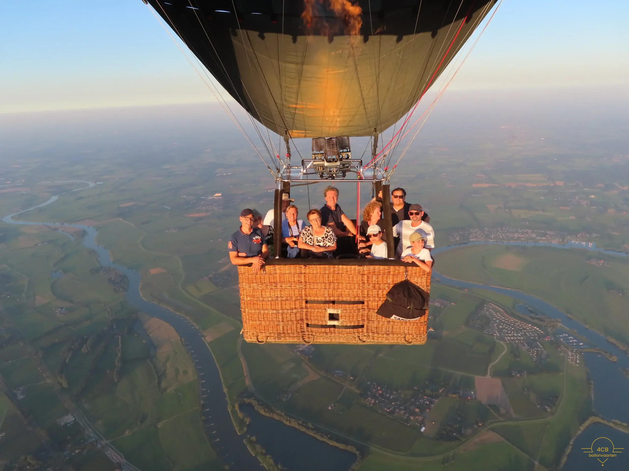 Ballonvaart Arnhem boven groen landschap bij zonsondergang