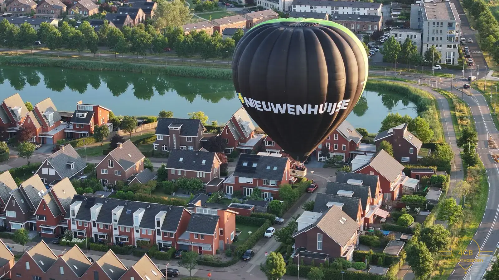 Ballonvlucht Duiven boven woonwijk en groen landschap